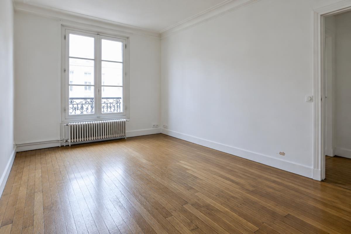 Illustration du séjour : parquet marqué et peinture à reprendre en pied de mur